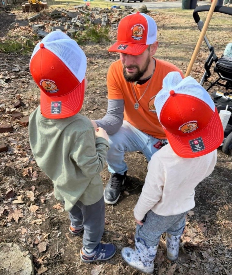 Mark kneeling with his three boys, all wearing Heavy Doody Scoops hats